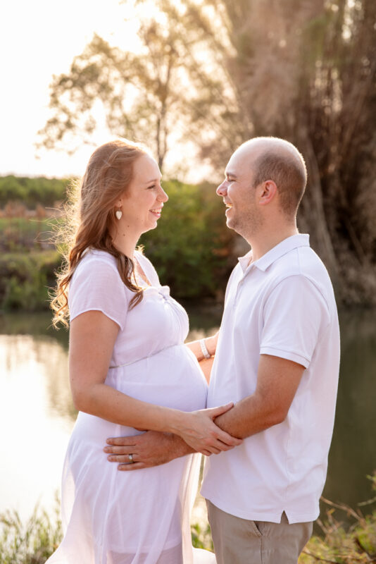 Soft natural light maternity photo of pregnant woman in flowing dress in Nelspruit