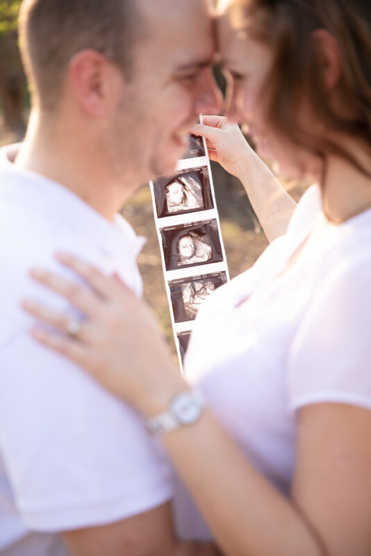 Pregnant woman and partner embracing during outdoor maternity shoot in Nelspruit