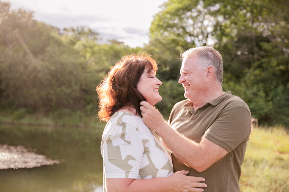 Grandparents embrace near a pond on a farm in Nelspruit