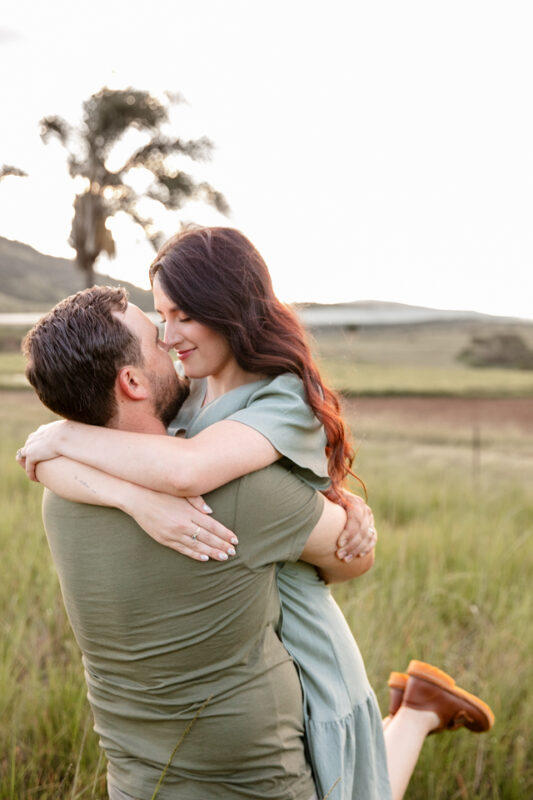 Parents holding hands and walking through tall grass