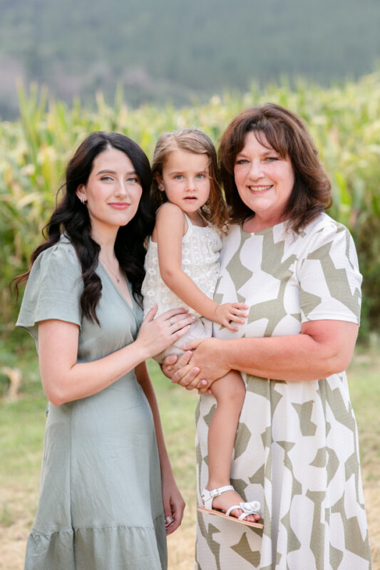 Family standing together under trees on farm