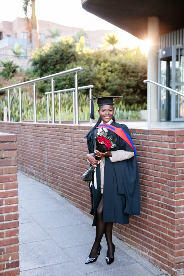 Graduate wearing academic gown and cap during graduation photoshoot at University of Mpumalanga